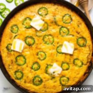 Jalapeño corn pudding, golden brown and bubbling, served directly from a cast iron skillet.