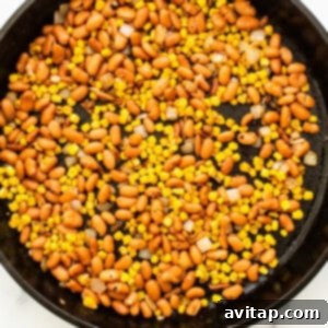 A skillet filled with beans and corn.