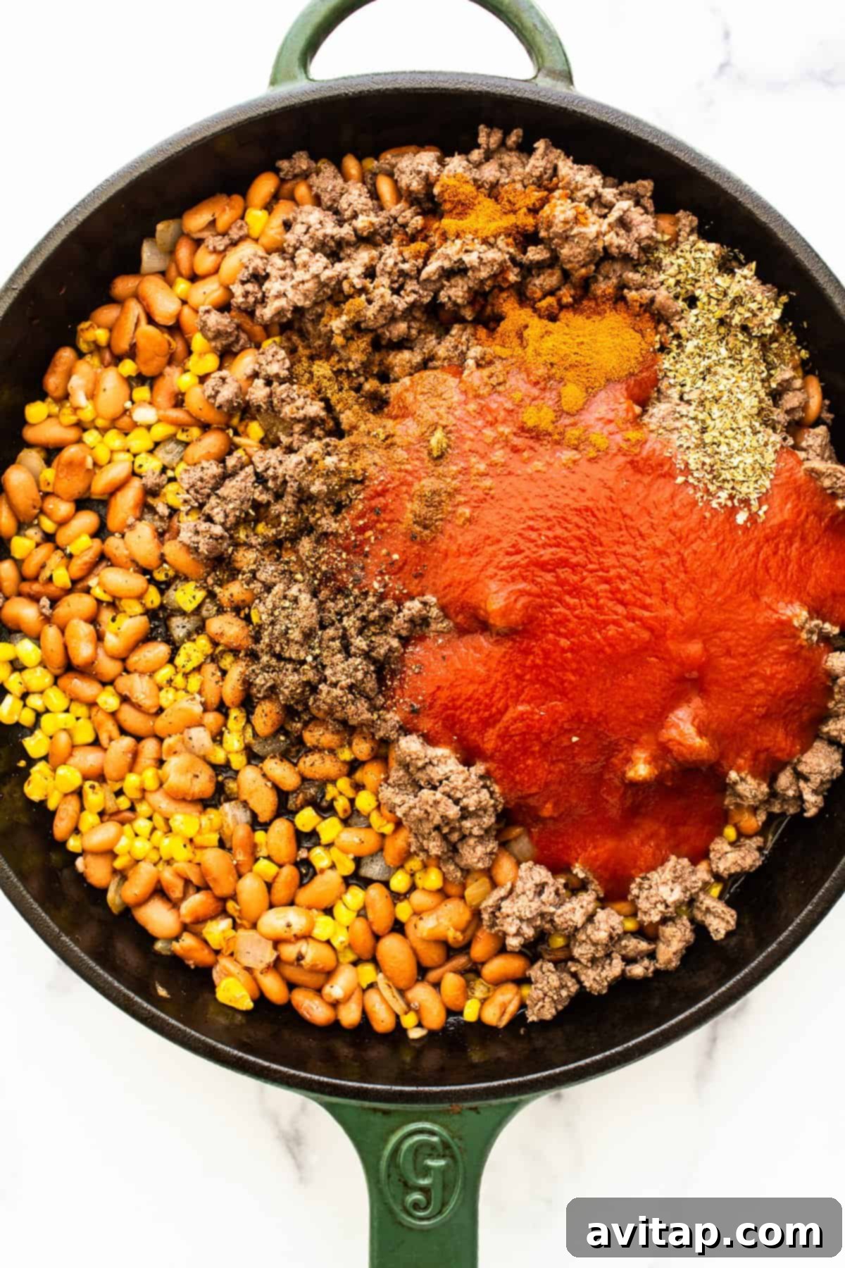 Ingredients for stuffed pepper filling in a cast iron skillet.
