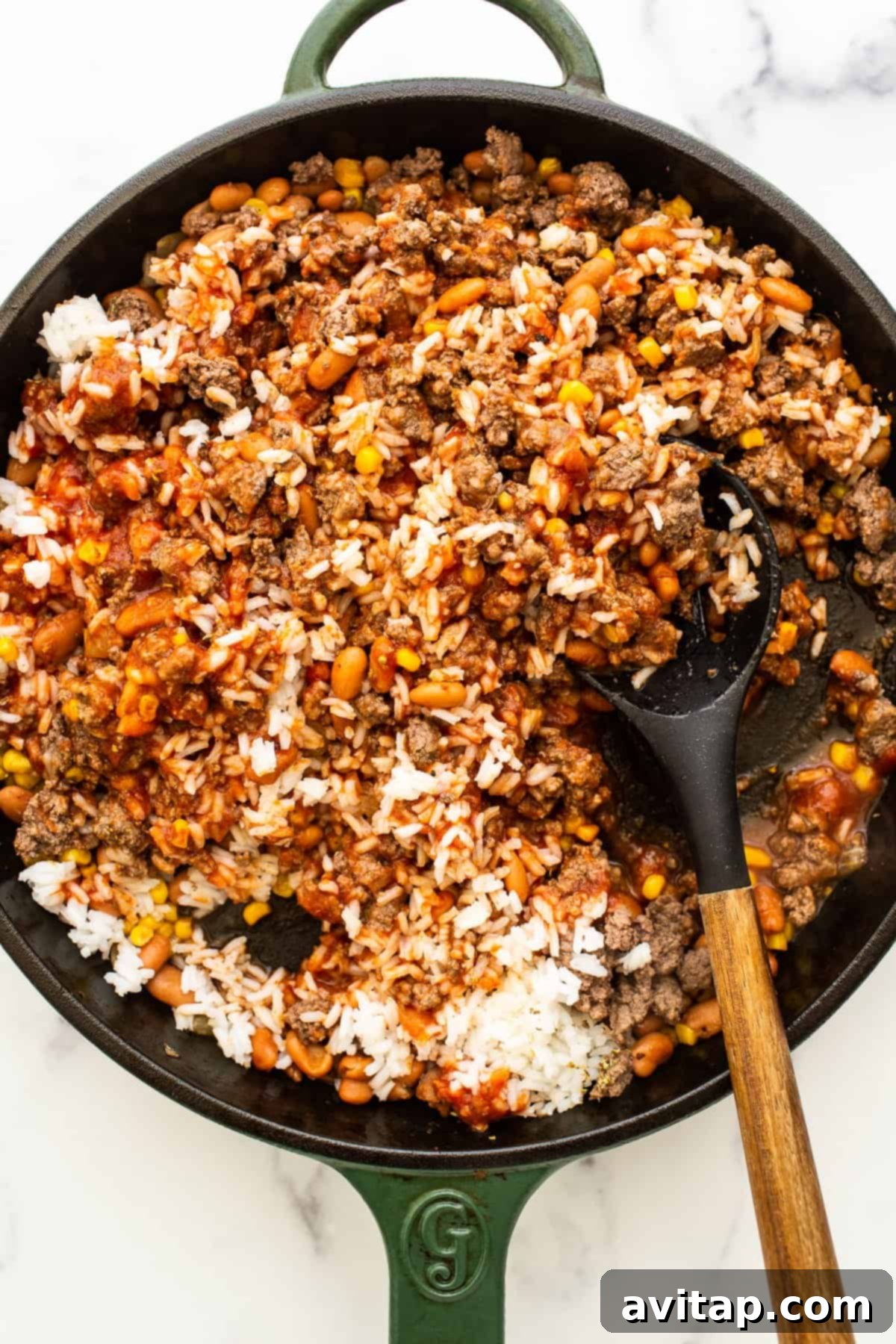 Rice, beans and ground beef in a cast iron skillet.