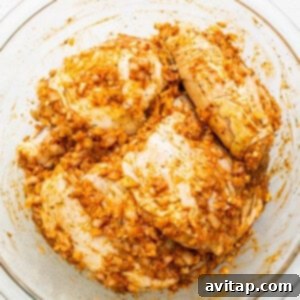 Chicken thighs marinating in a flavorful sauce in a bowl.