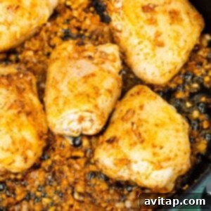 Chicken breasts searing in a skillet on the stove.