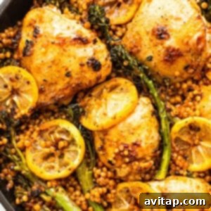 A skillet full of cooked chicken, broccolini, and lemons, fresh from the oven.