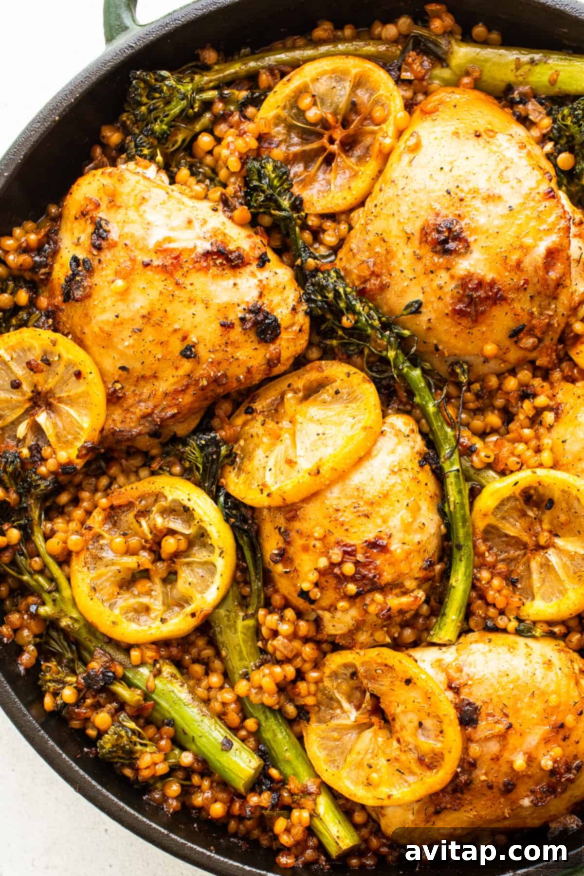 Completed Lemon Chicken Skillet, fresh from the oven, with couscous and broccolini.