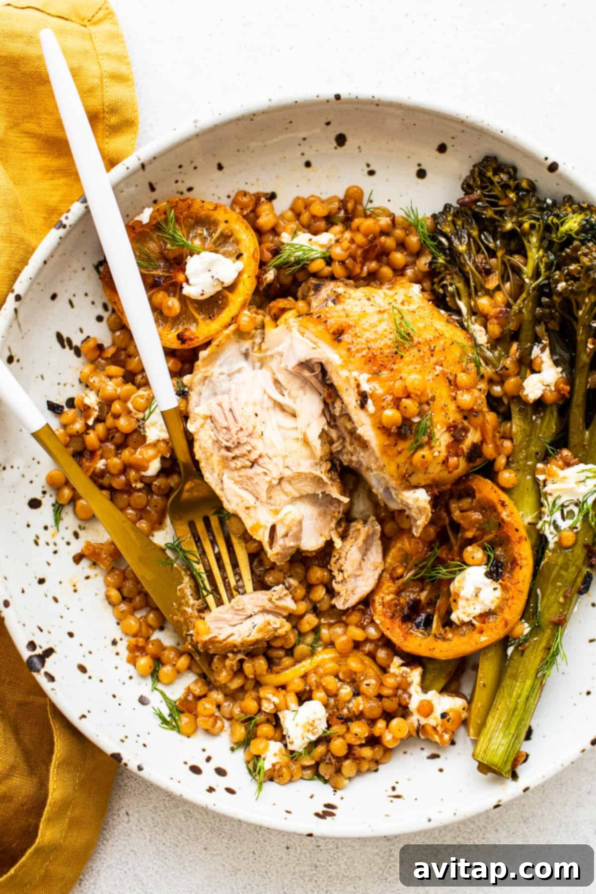 A serving of Lemon Chicken Skillet on a white plate, garnished with dill and goat cheese.