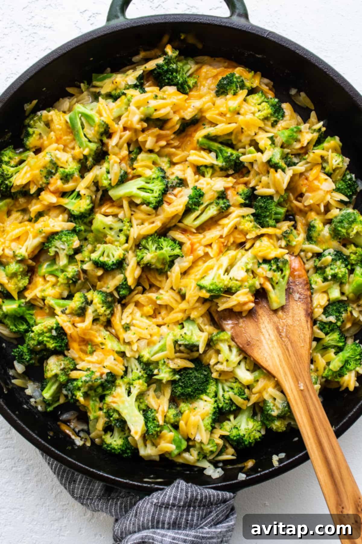 Delicious Broccoli Cheese Casserole with Orzo in a Cast Iron Skillet Cheesy broccoli casserole, rich and golden, bubbling in a rustic cast iron skillet, ready to be served.