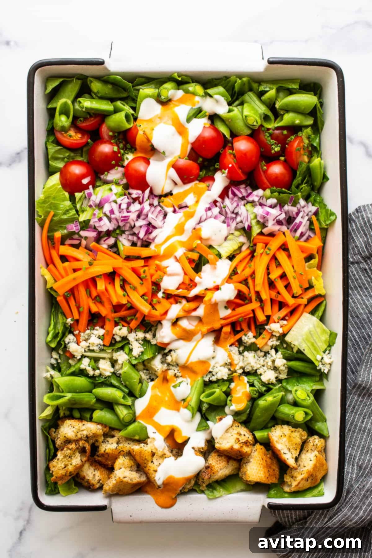 Eat the rainbow with this ultimate garden salad and homemade croutons tossed in French and blue cheese dressing. Enjoy as a side or a main dish! A beautifully presented garden salad in a large serving dish, generously topped with a medley of fresh vegetables, golden homemade croutons, and drizzled with a rich salad dressing, ready to be enjoyed.