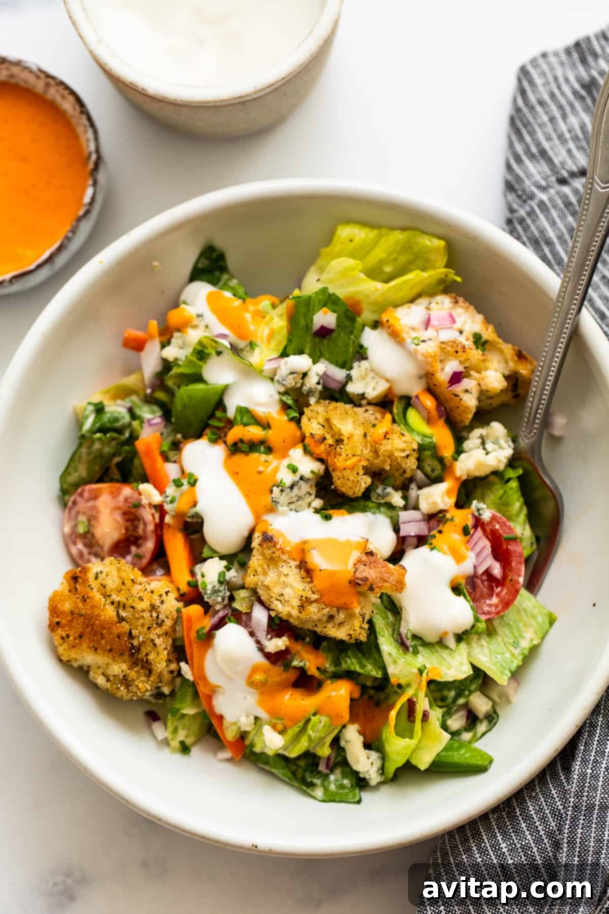 Eat the rainbow with this ultimate garden salad and homemade croutons tossed in French and blue cheese dressing. Enjoy as a side or a main dish! A vibrant, freshly tossed garden salad served in a white bowl, with a fork resting on the side, inviting you to take a bite.