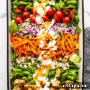 Ultimate garden salad after adding croutons and blue cheese, drizzled with dressing.