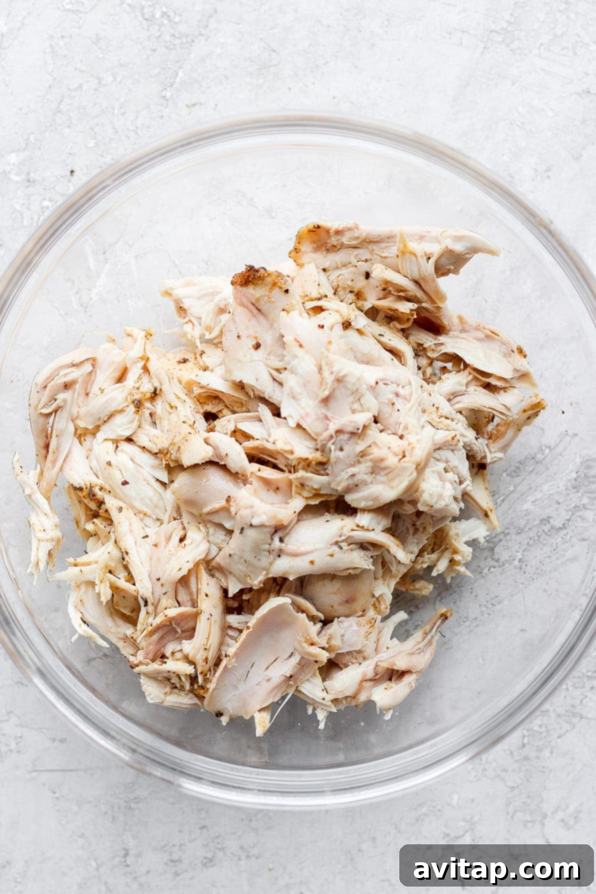 A bowl filled with perfectly plain shredded chicken, ready to be tossed with the creamy, spicy buffalo sauce.