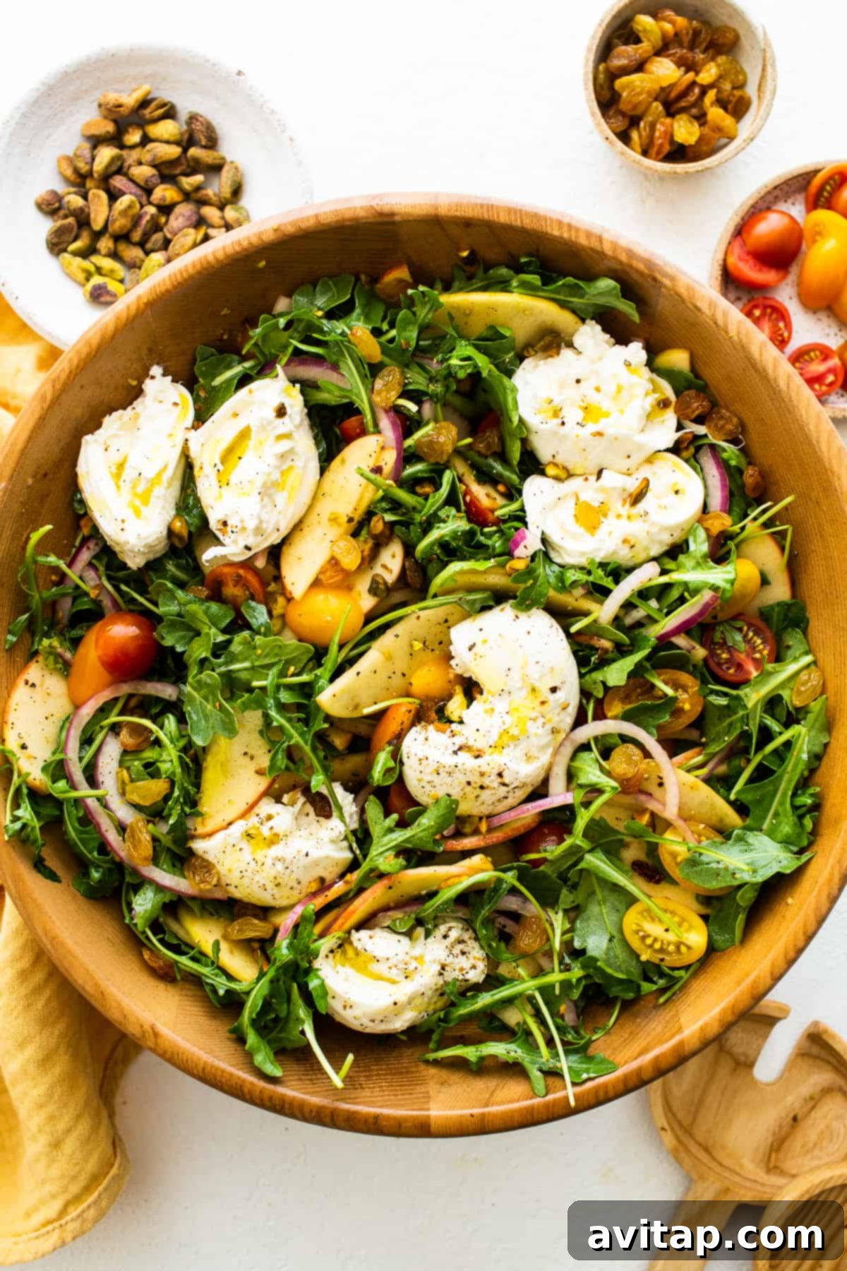 Apple burrata salad with ripped burrata on top of the salad, ready to be served.