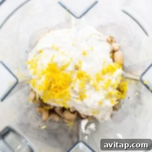 Effortless Vegan Cheesecake Bars 10 Blender filled with soaked cashews, lemon juice, zest, and coconut cream being blended for the velvety vegan cheesecake filling.
