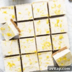 Effortless Vegan Cheesecake Bars 12 Perfectly sliced lemon vegan cheesecake bars, artfully topped with cashew cream and nuts, ready to be enjoyed.