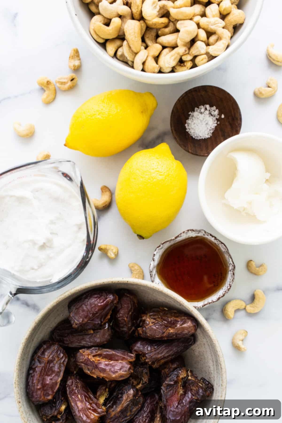 Effortless Vegan Cheesecake Bars 3 A vibrant still life of key ingredients for vegan cheesecake bars, featuring a bowl of plump Medjool dates, a scattering of raw cashews, and bright, fresh lemons, ready for preparation.