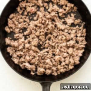 Weeknight Pork Noodles 5 Ground pork browning in a frying pan on a stovetop.