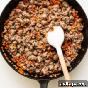 Weeknight Pork Noodles 6 A skillet filled with ground pork, minced carrots, and green onions, mixed together.