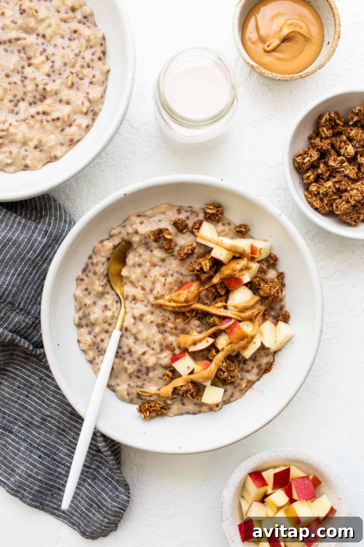 Creamy Apple Cinnamon Oatmeal A comforting bowl of apple cinnamon oatmeal with a spoon resting gently inside, perfectly cooked and invitingly ready to be enjoyed.