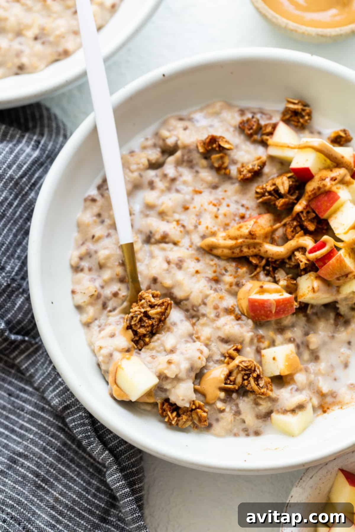 Apple Cinnamon Oatmeal with Granola A hearty and appealing bowl of apple cinnamon oatmeal, generously topped with crunchy granola, ready to be enjoyed as a wholesome and satisfying breakfast.