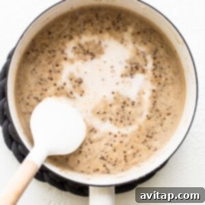 A pot of oatmeal simmering gently, with a spoon stirring the creamy mixture to ensure perfect consistency.