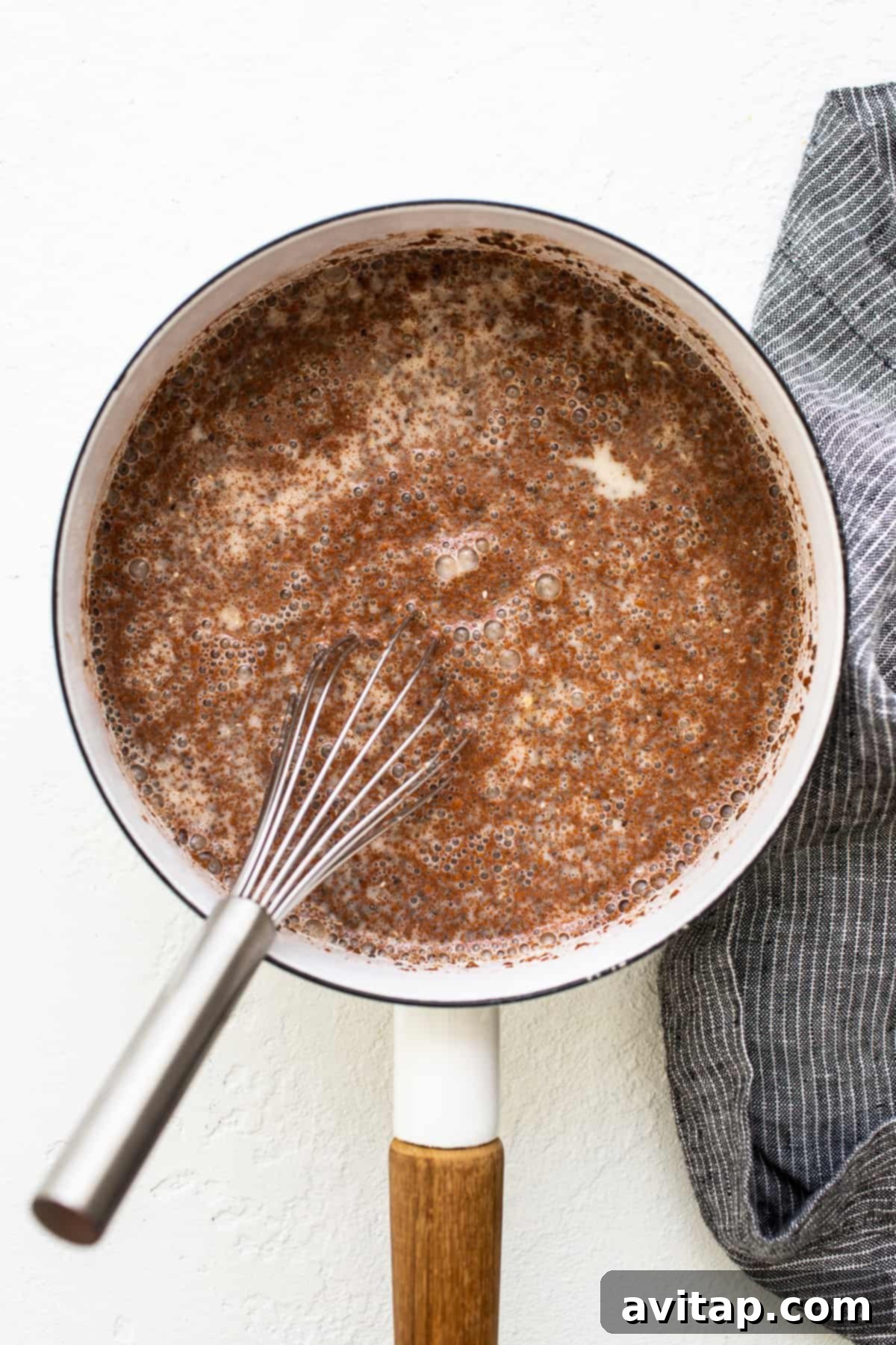 Oatmeal Simmering on the Stovetop Apple cinnamon oatmeal simmering gently in a saucepan on the stovetop, releasing a delicious, comforting aroma as it slowly thickens to perfection.