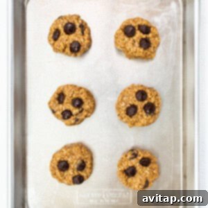 Chocolate chip cookies arranged on a baking sheet before going into the oven.