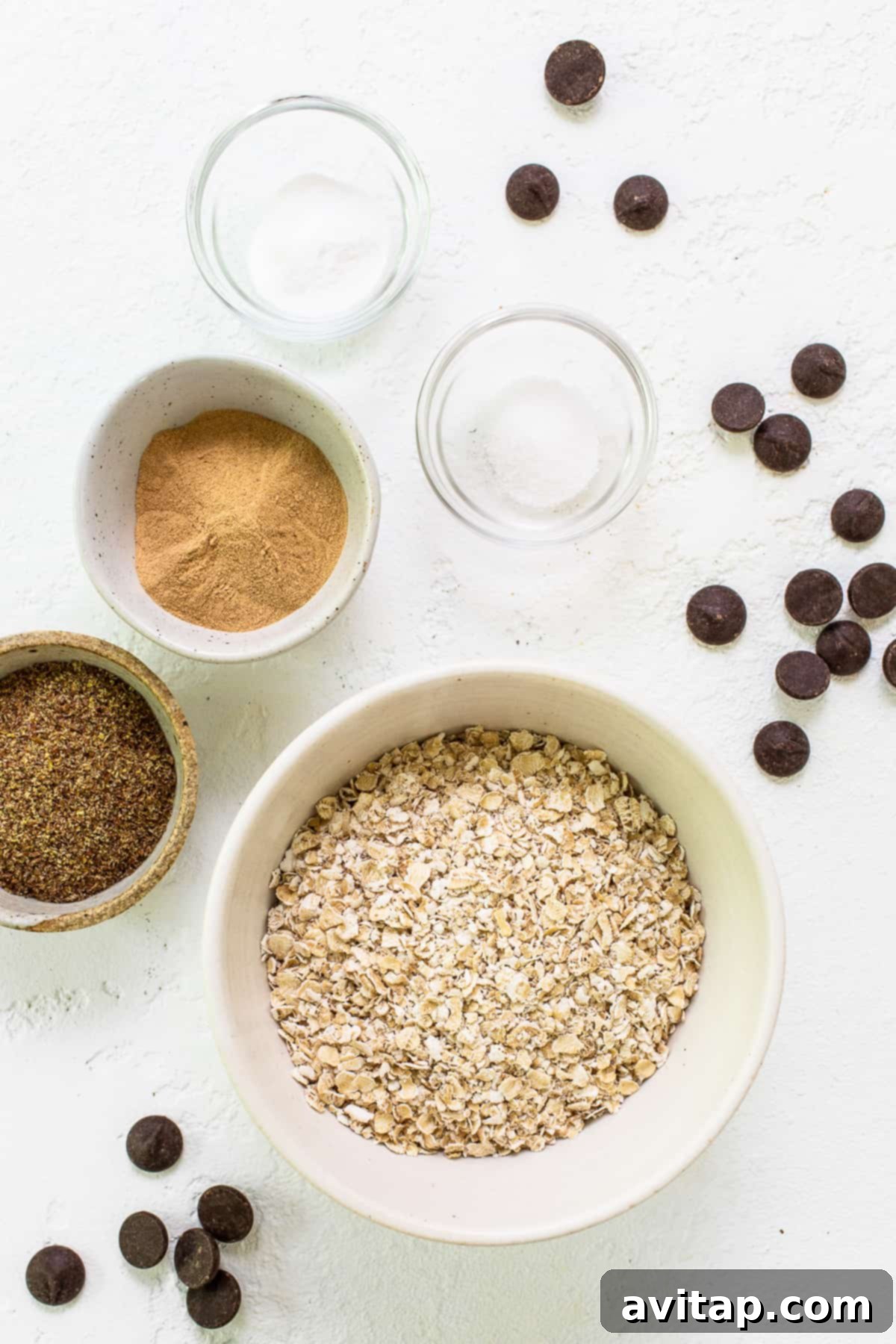 A bowl filled with the fresh ingredients for making lactation cookies, including oats, flaxseed meal, and chocolate chips.
