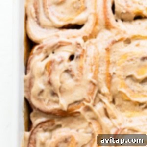 Beautifully frosted apple cinnamon rolls in a square dish.