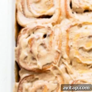 Frosted apple cinnamon rolls in a dish.