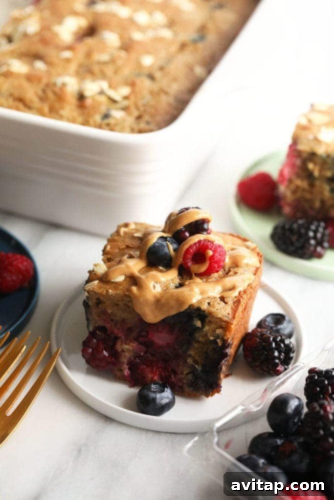 A freshly baked slice of triple berry breakfast bread, adorned with a medley of fresh berries, resting on a rustic wooden plate.