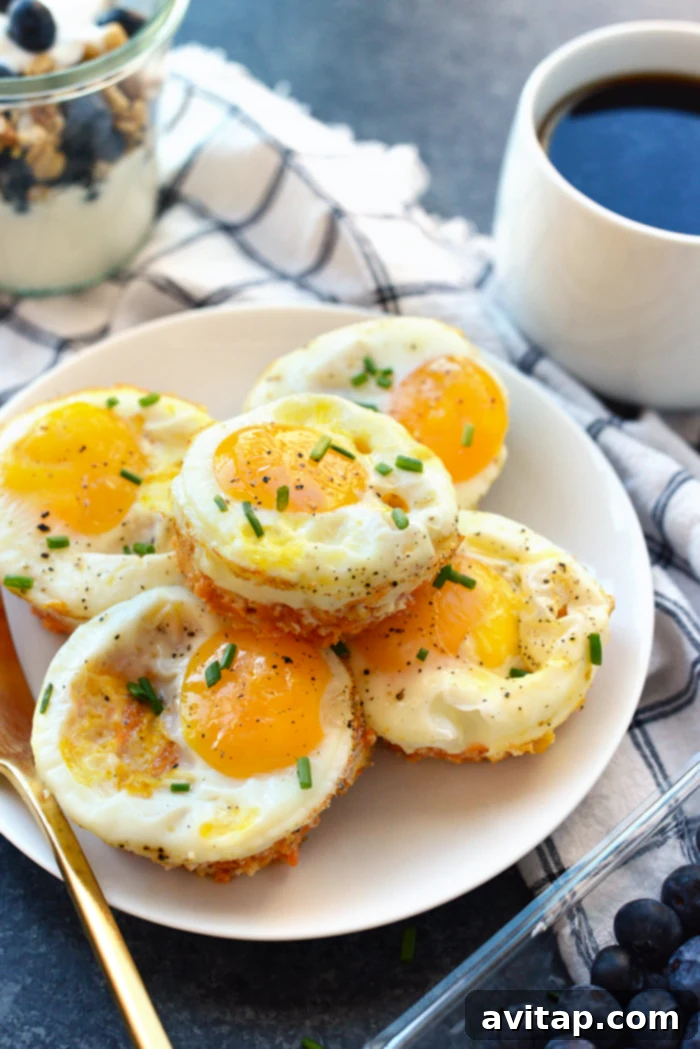 Individual sweet potato hash egg cups, baked to golden perfection, served on a white plate and garnished with fresh parsley.