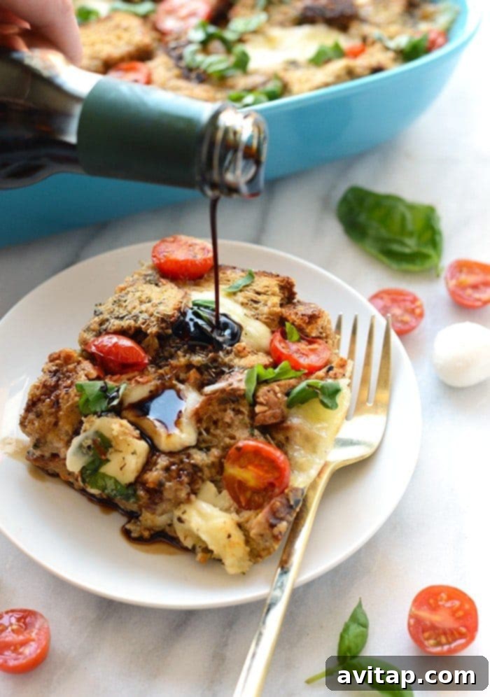 A beautifully baked Caprese Egg Bake, showcasing golden-brown bread cubes, melted mozzarella, and bright red tomatoes, generously garnished with fresh basil leaves and a drizzle of balsamic glaze. This savory breakfast casserole is perfect for brunch.