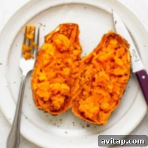 A sweet potato cut in half on a plate.