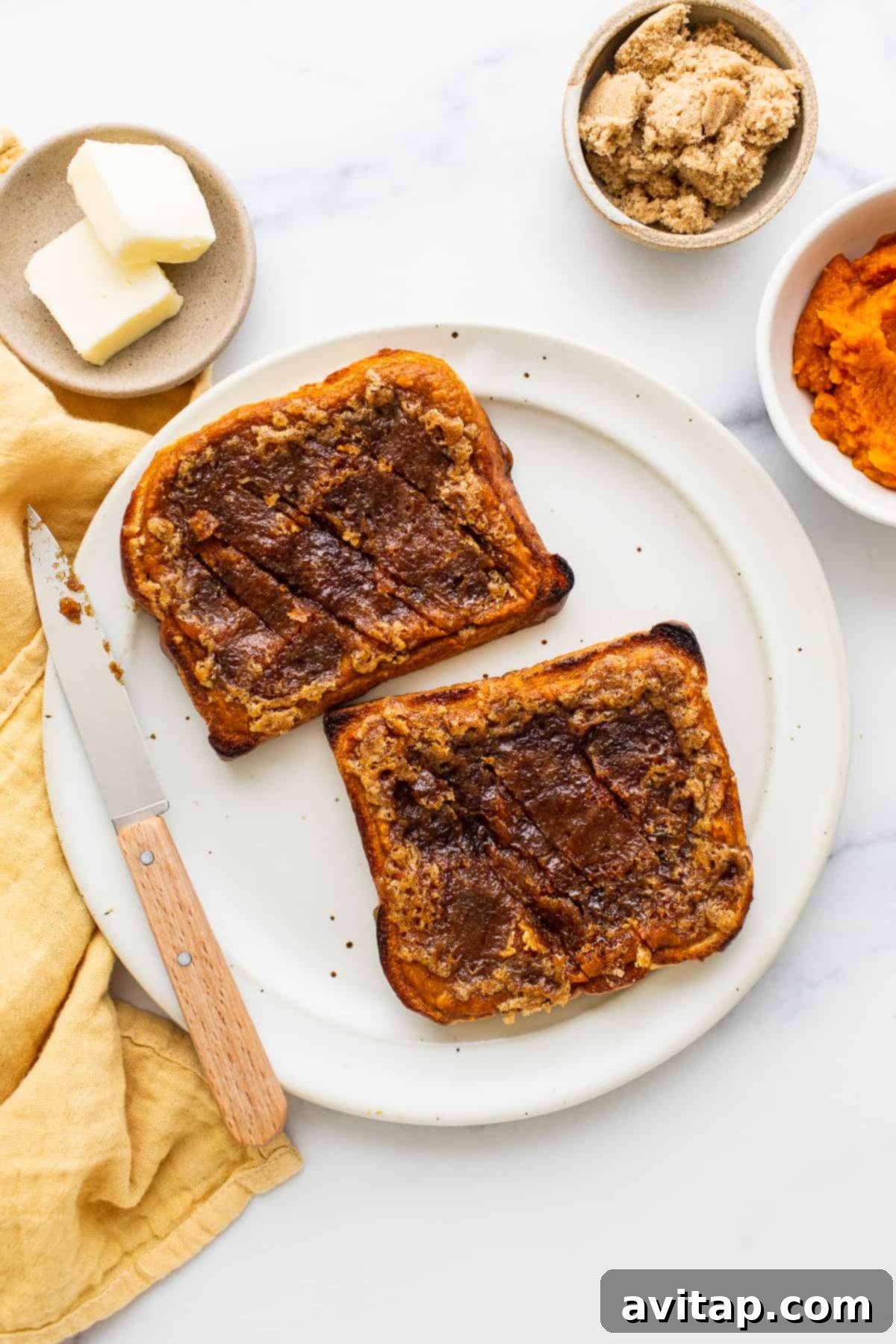 Ready-to-Serve Pumpkin Creme Brûlée French Toast A slice of Pumpkin Creme Brûlée French Toast on a plate with a knife, ready to be cut.
