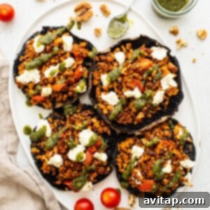 Plated stuffed mushrooms with pesto drizzle, ready for serving.