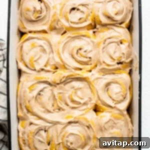 Spiced Pumpkin Cinnamon Rolls 11 Pumpkin cinnamon rolls in a baking dish.
