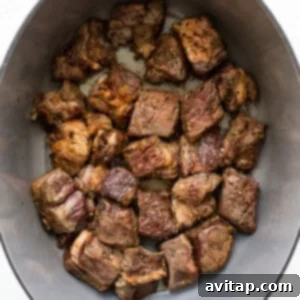 Cooking beef chunks in a hot Dutch oven, searing to a perfect golden-brown.