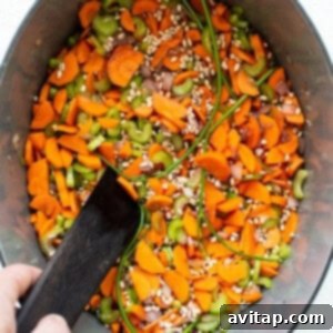 A colorful mix of vegetables and barley simmering in a pot.