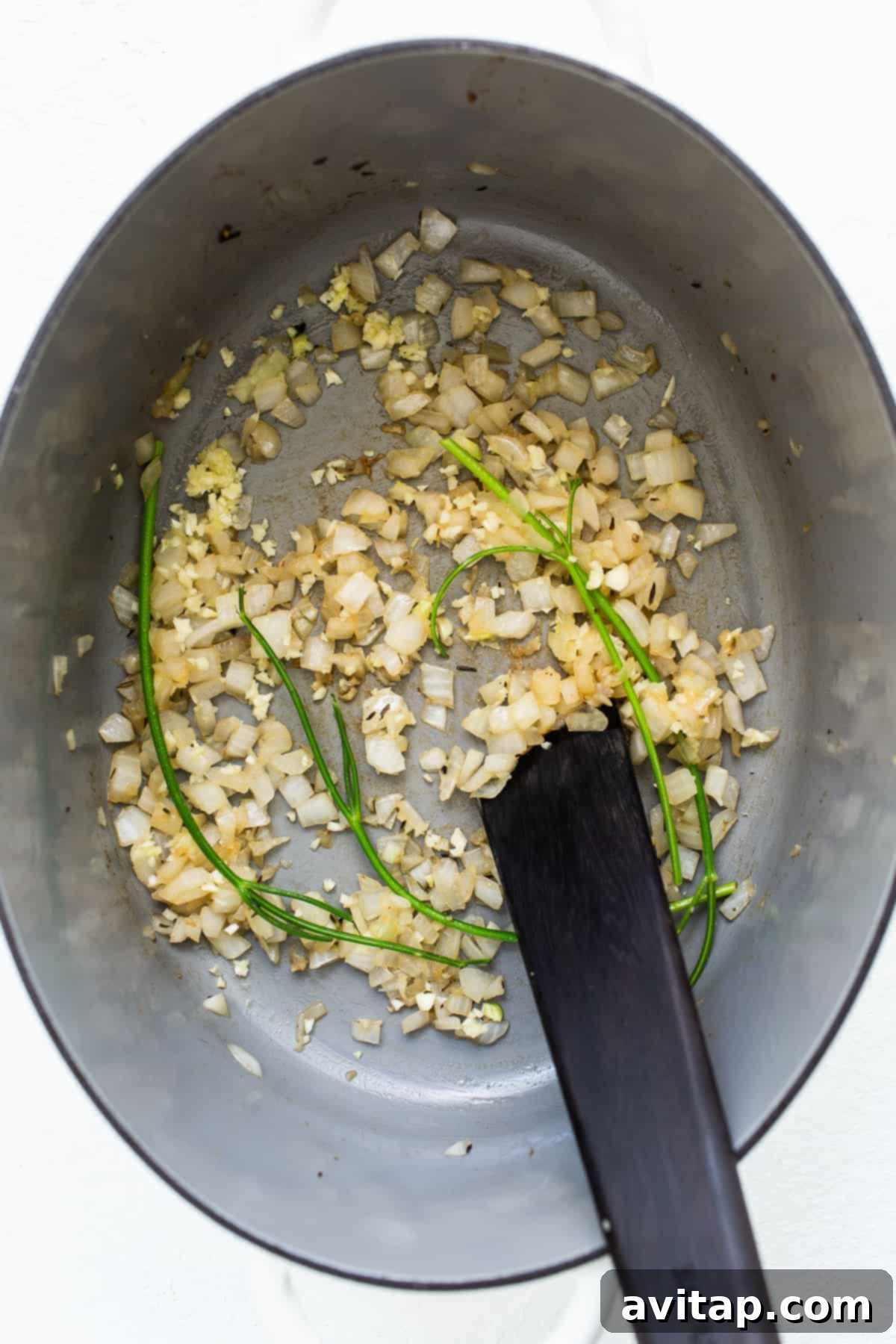 Sautéing diced onions in a large Dutch oven, releasing their sweet aroma.