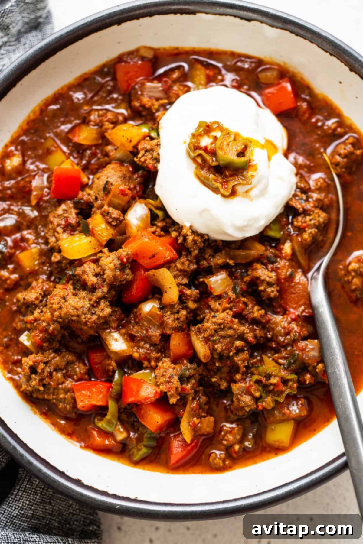 A bowl of rich Texas chili topped with sour cream, ready to be served.