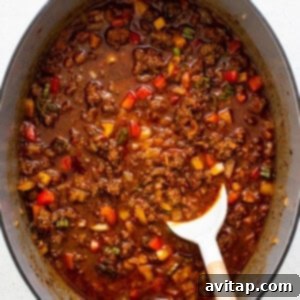 Texas chili simmering in a pot on the stove.