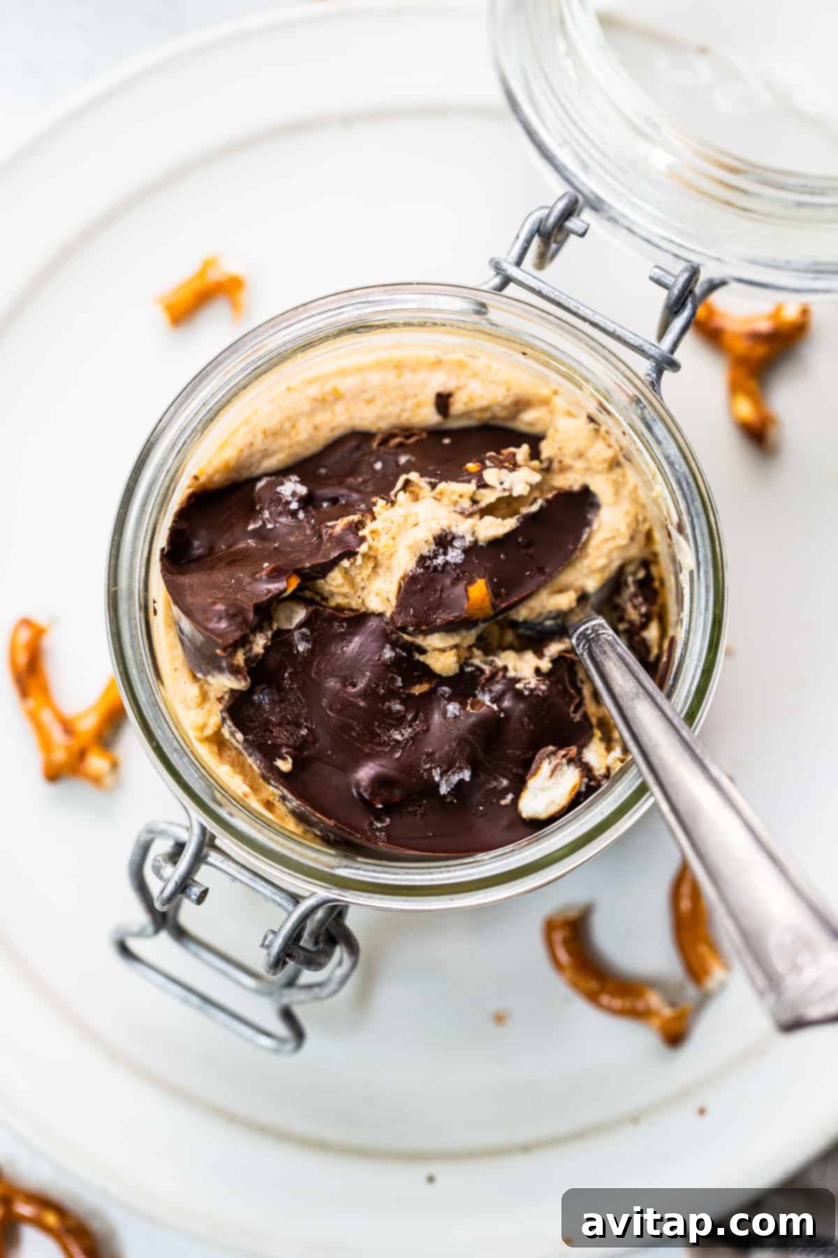 Pumpkin mousse in a jar topped with a rich chocolate pretzel topping, ready to be enjoyed.