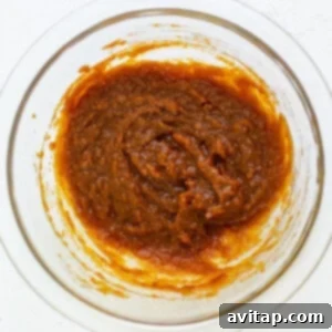 A bowl with a brown sauce in it.