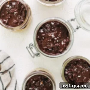 Chocolate pudding in jars on a white table.