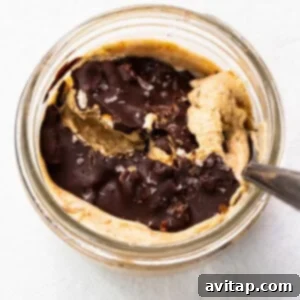 Peanut butter in a glass bowl with a spoon.