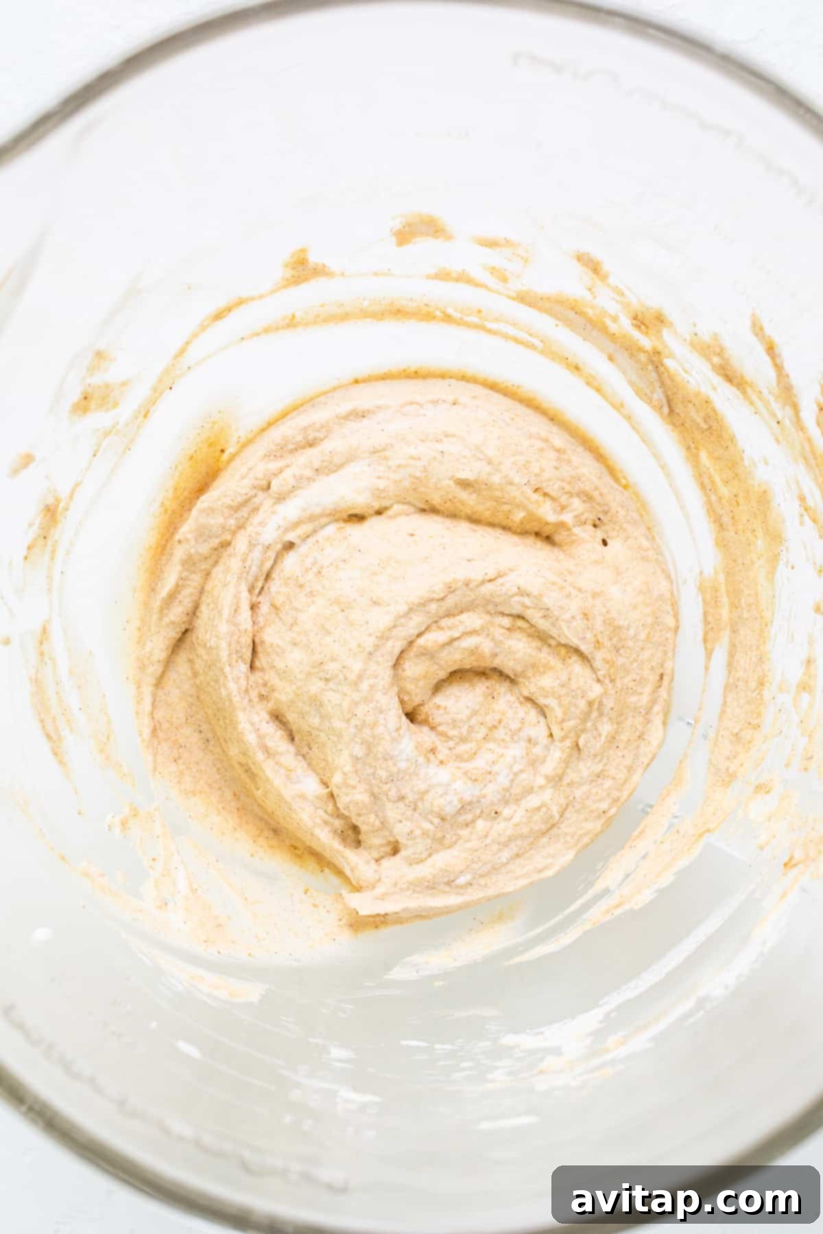 A close-up shot of a single serving of pumpkin mousse in a clear jar, showcasing its light orange color and fluffy texture.