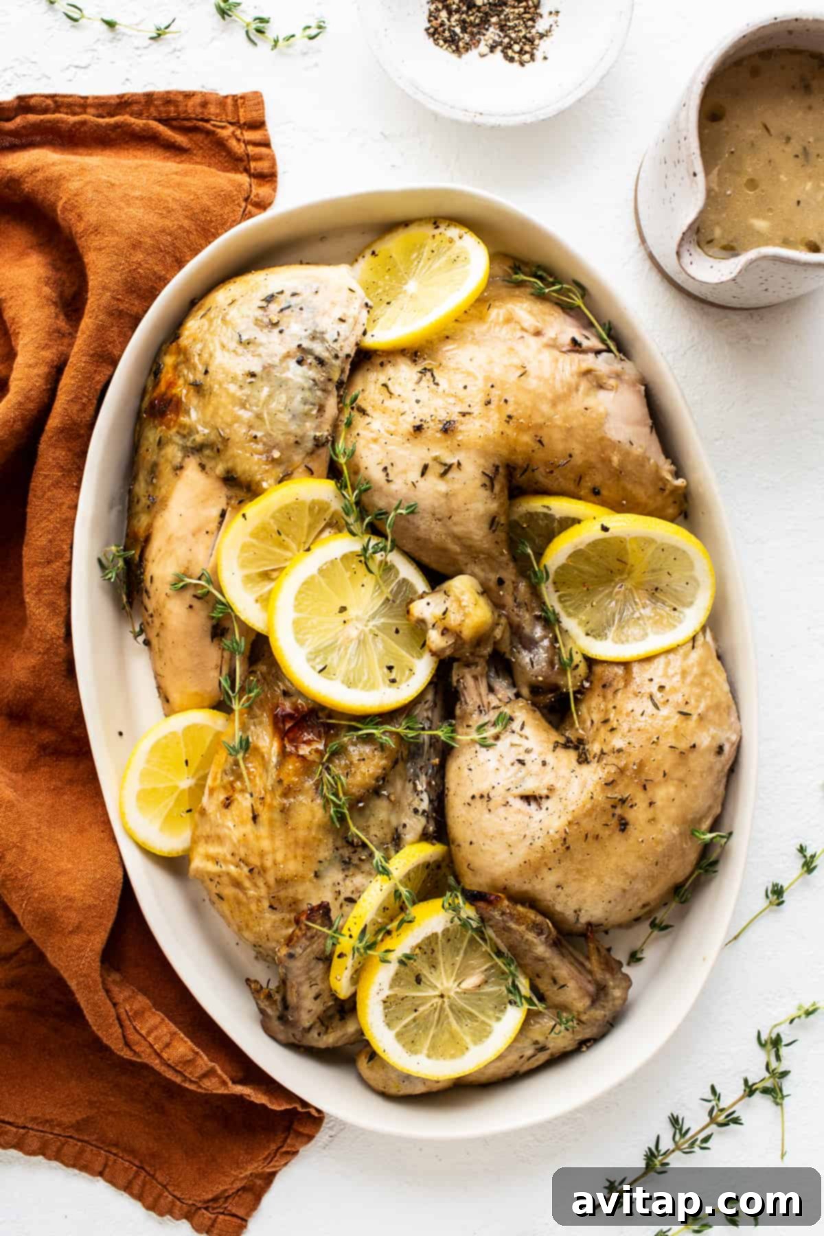Carved Instant Pot Whole Chicken A beautifully carved Instant Pot whole chicken displayed on a pristine white platter, garnished with vibrant fresh herbs and bright lemon slices, highlighting its readiness for serving.