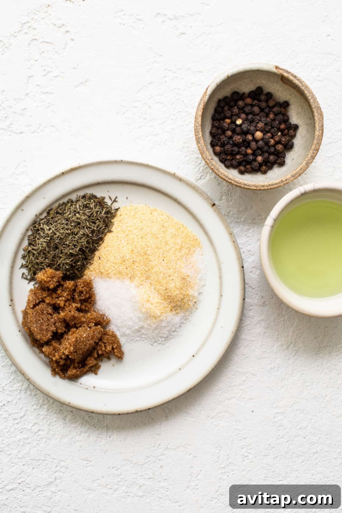 Essential Instant Pot Whole Chicken Spices A vibrant array of spices for the chicken rub, including black pepper, granulated garlic, brown sugar, thyme, and kosher salt, laid out on a plate, showcasing the key flavor components.