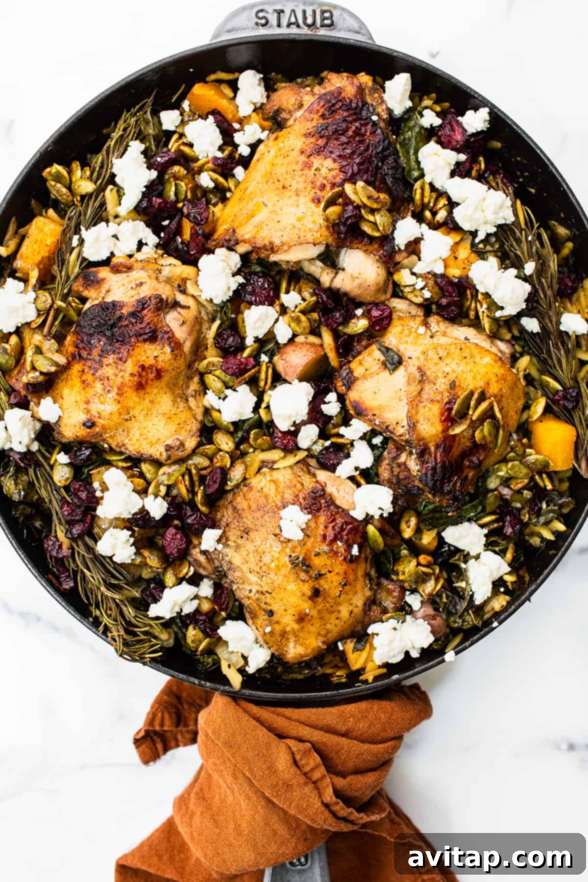 One-Pan Harvest Orzo Dinner 2 Harvest orzo chicken skillet topped with goat cheese and pepitas, ready to serve.