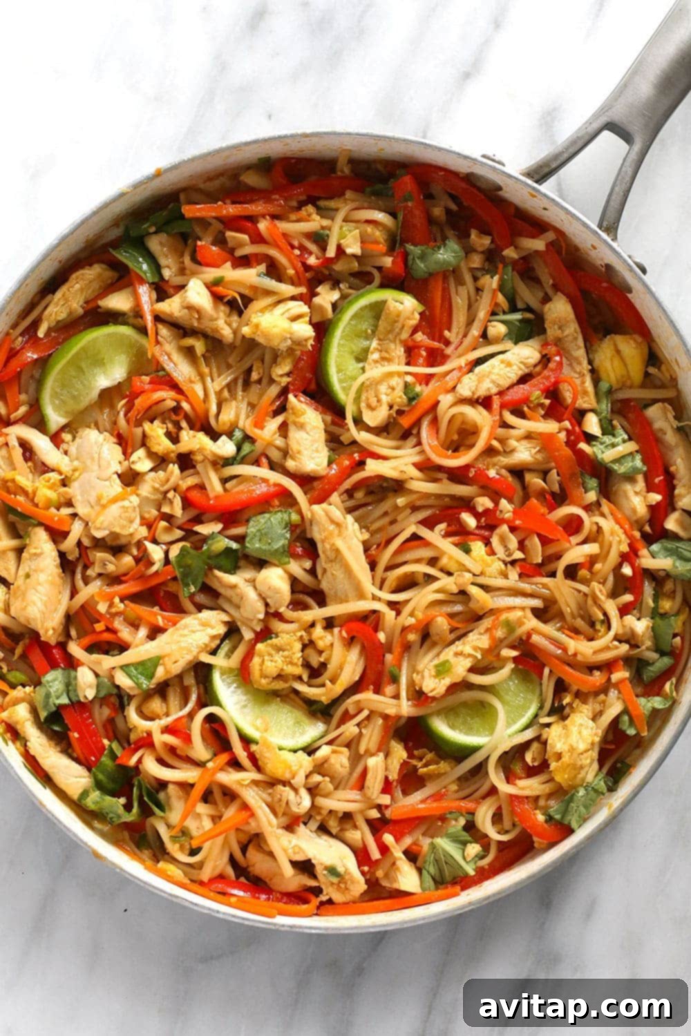 A delicious pan of freshly cooked Chicken Pad Thai, expertly mixed and ready to be served.