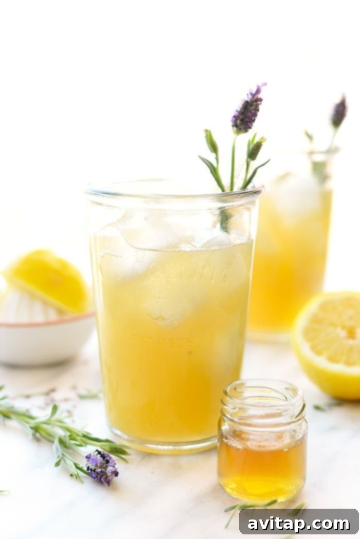 Honey Lavender Lemonade: Perfectly Refreshing and Naturally Sweetened Vibrant lavender lemonade garnished with fresh lavender sprigs and lemon slices, inviting a refreshing sip.